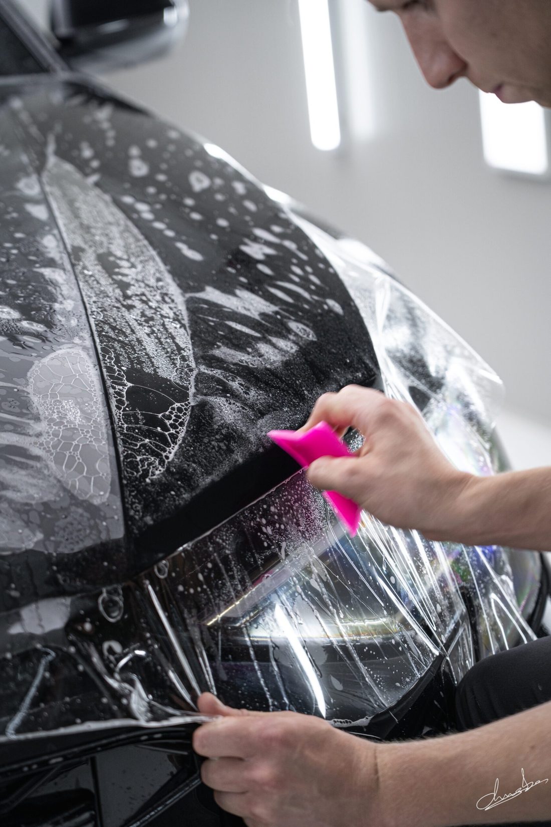 Paint protection film wordt over een koplamp gespannen