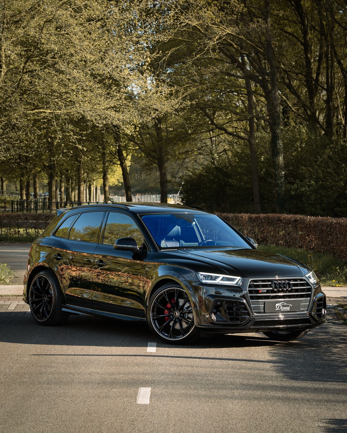 Zwarte Audi SQ5 ABT op een bosweg na de detailing