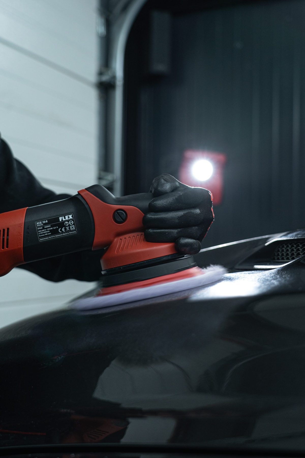 Polijstmachine met werklamp op een donkere lak