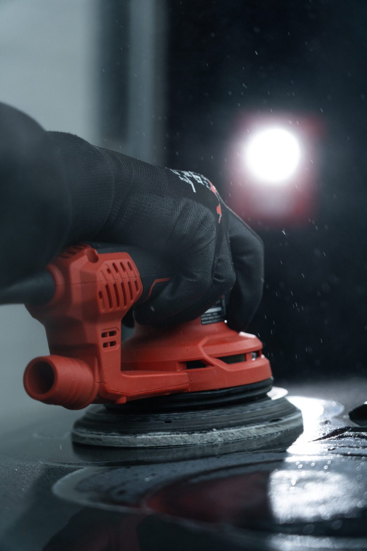 Polijstmachine met werklamp op een donkere lak